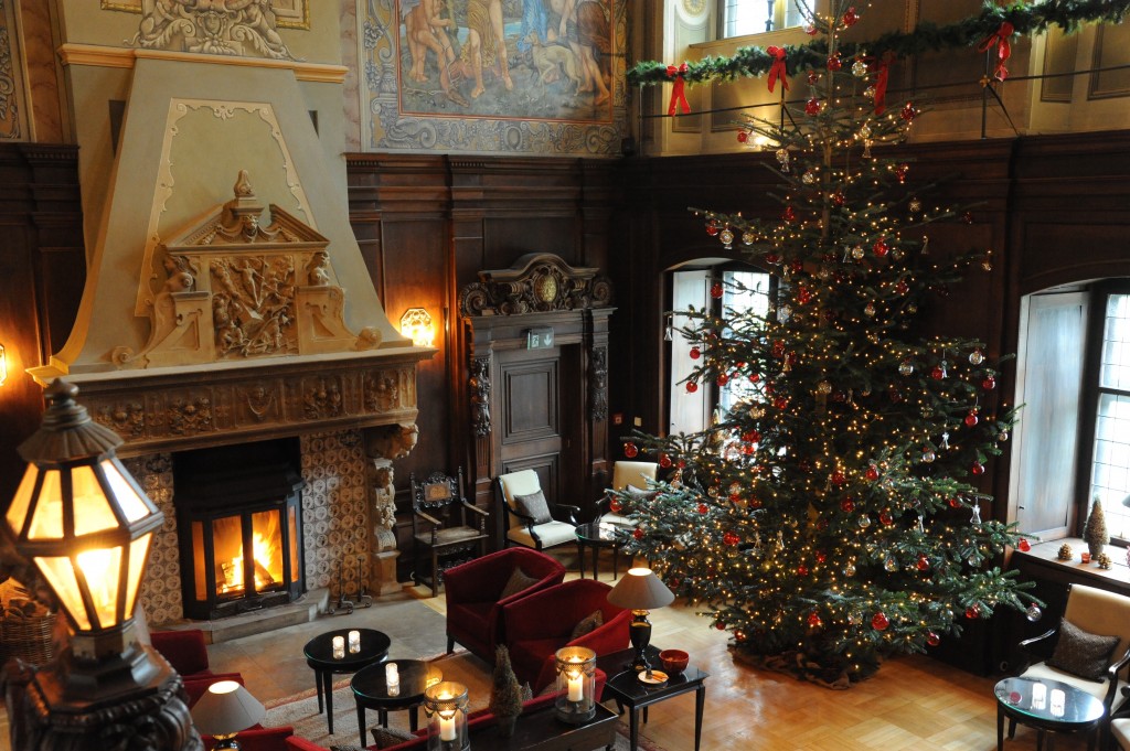 festlich geschmückter Weihnachtsbaum im Rittersaal neben dem Kamin