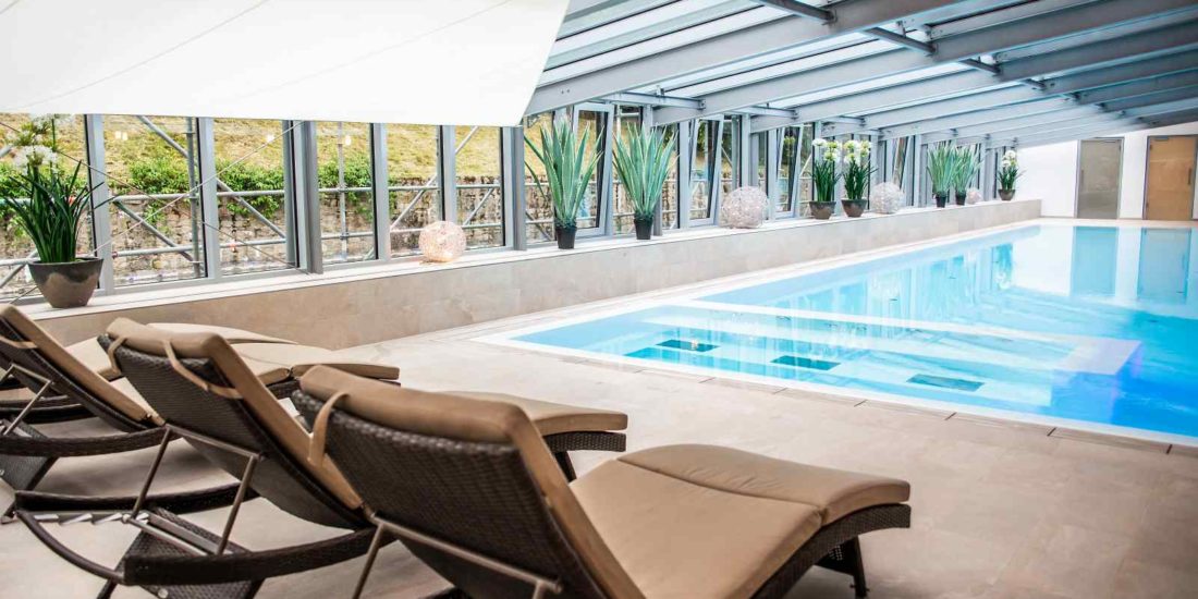 Moderner Wellnessbereich mit Pool, Tageslicht und Designliegen im Schlosshotel