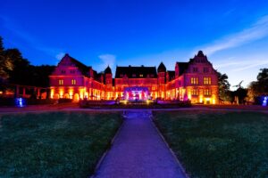 Abendliches Schloss mit stimmungsvoller Illumination und Projektion auf der Fassade